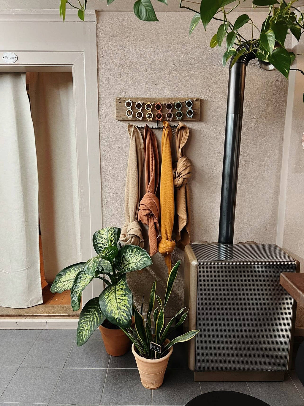 Organic cotton muslin blanket displayed in a home setting, with neutral colors hanging on a coat rack.