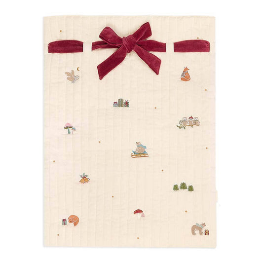 Beige fabric with a red velvet bow and small embroidered designs on a white background