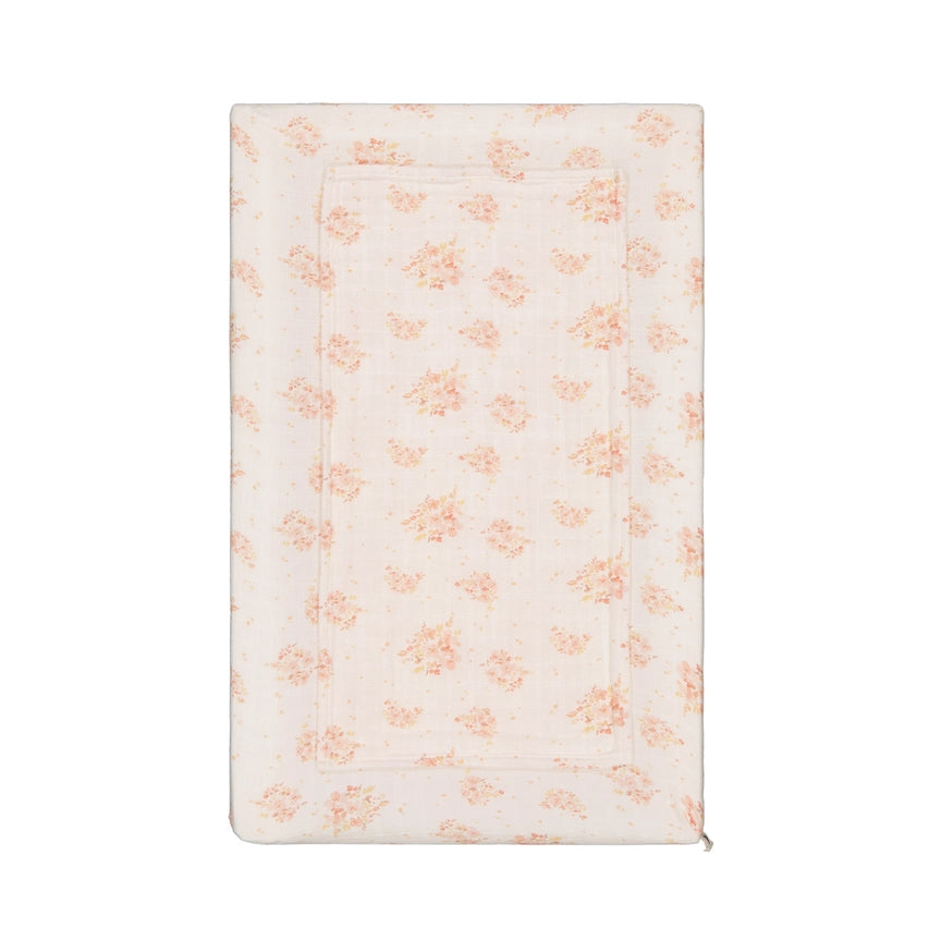 Cream changing mat cover with an all-over peach floral bouquet print, shown flat against a white background.