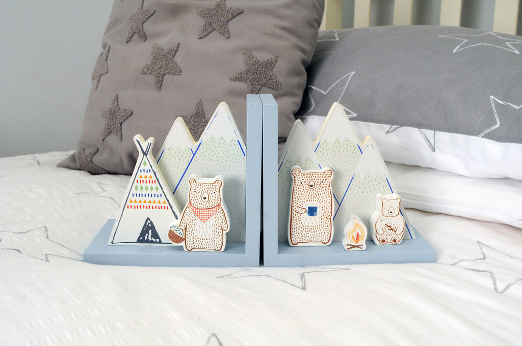 Camping bear bookends with illustrated bears, mountains, tents and campfire on a child’s bed