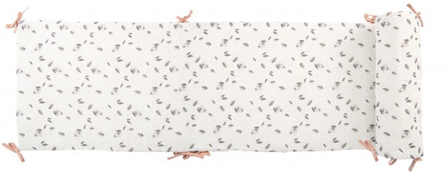 Cream After the Rain cot bumper shown laid out flat, featuring a repeating grey rabbit and leaf pattern with pink fabric tie fastenings