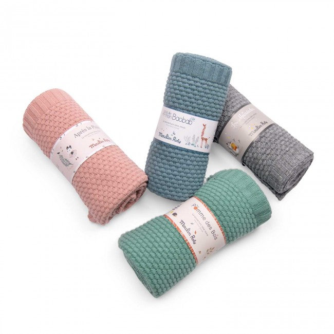 Dusky pink wool blend knitted blanket shown with blue, grey and green knitted blankets on a white background