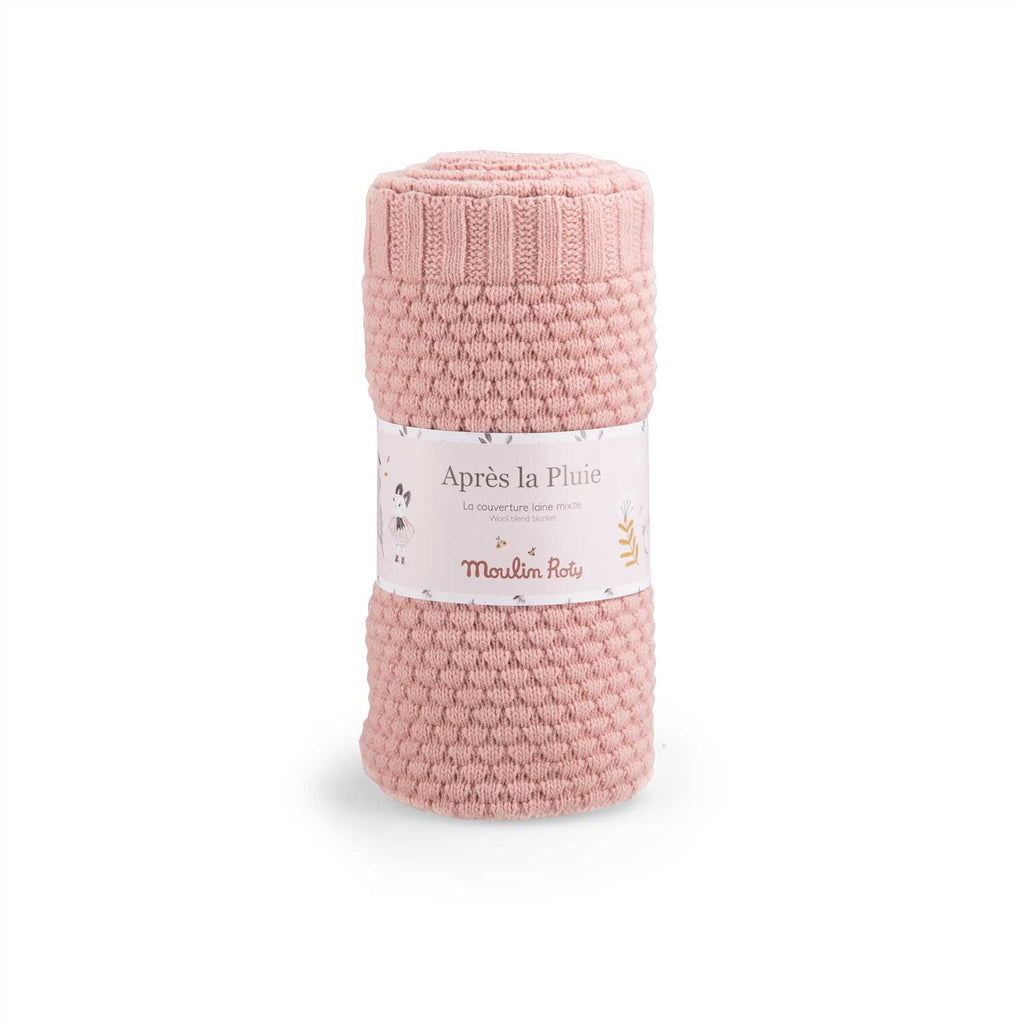 Dusky pink wool blend knitted baby blanket rolled and displayed in Moulin Roty packaging on a white background
