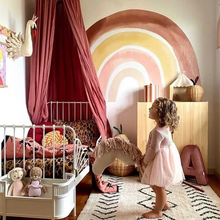 Felt swan wall décor displayed in a colourful nursery beside a child’s bed