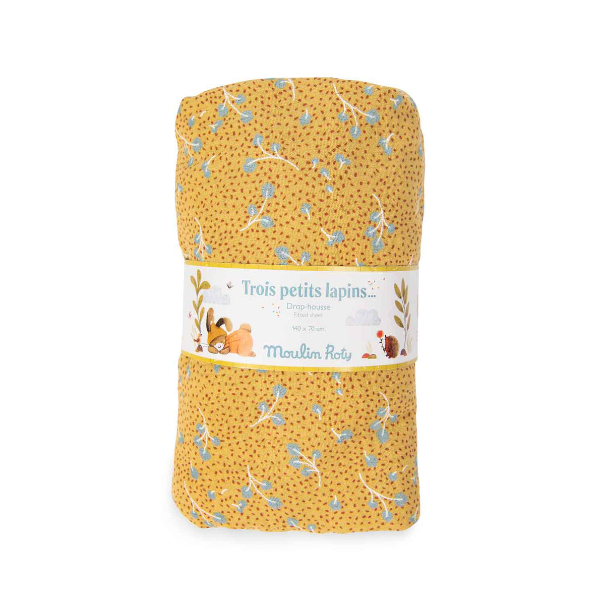 Rolled ochre fitted cot sheet with a delicate blue leaf pattern and Three Little Rabbits packaging on a white background
