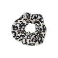 Graou Greige scrunchie featuring a bold black leopard print on a light greige cotton fabric, displayed against a white background.