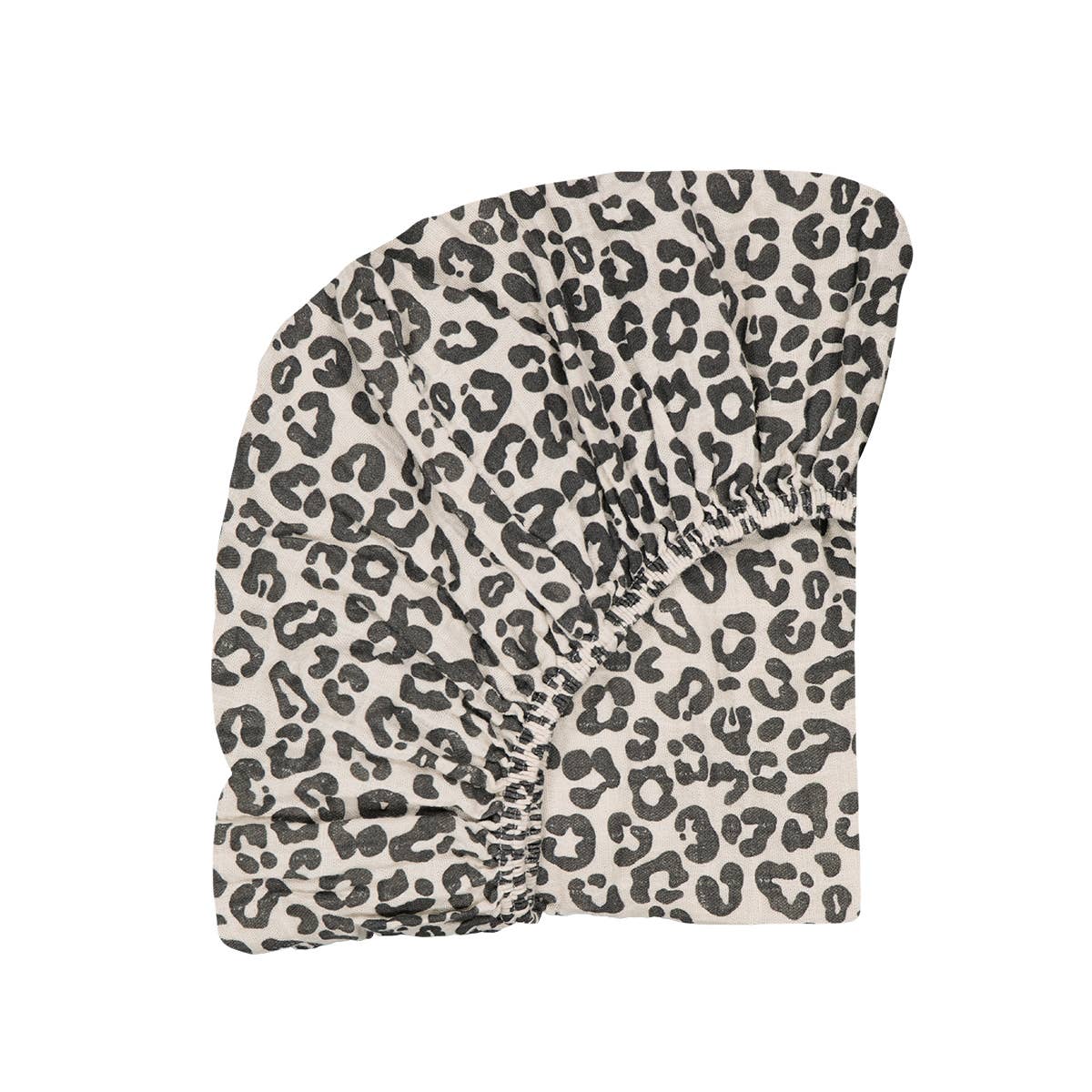 Graou fitted cot sheet in cream with a bold black monochrome animal print and elasticated edges.