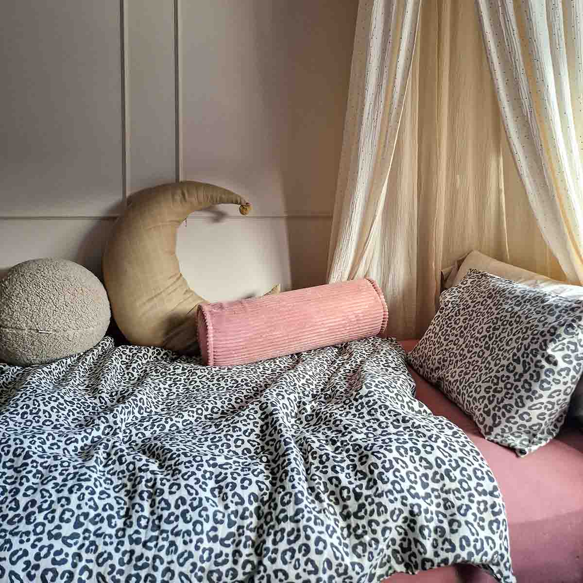 Graou Plume print cotton bed linen set featuring a grey and white animal print duvet cover and matching pillowcase, styled on a pink child's bed with a crescent moon cushion and neutral nursery decor.