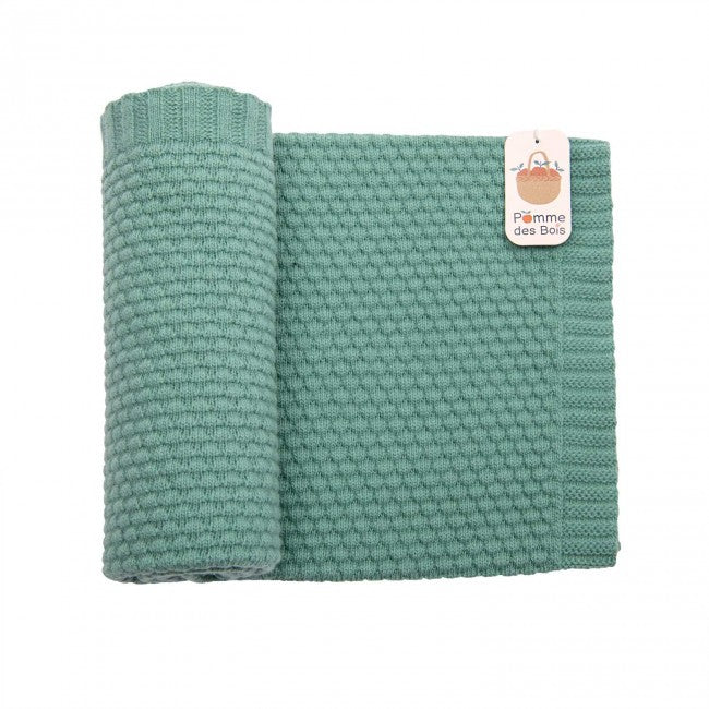 Green wool blend knitted baby blanket laid flat on a white background, showing its textured knit pattern and ribbed edge