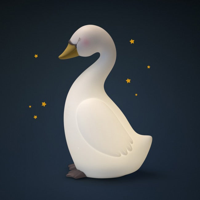 White swan-shaped night light glowing softly against a dark navy background with small yellow stars.