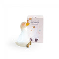 Moulin Roty The Little Dance School rechargeable swan night light glowing softly beside its pink and cream product packaging featuring a swan illustration.