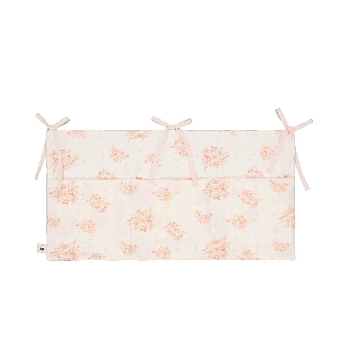 Mathilde Bouquet crib organiser in cream with a delicate peach floral print, three front storage pockets and three pairs of fabric ties for attaching to a cot.