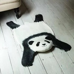 Ping the Panda felt rug lying on a light wooden floor in a room