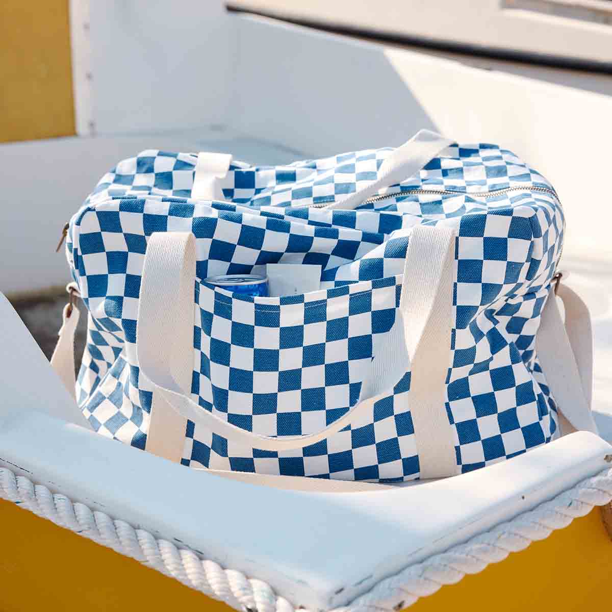 Raphael Checkerboard Blue nappy bag displayed open to show its zip fastening, spacious interior and front exterior pocket.