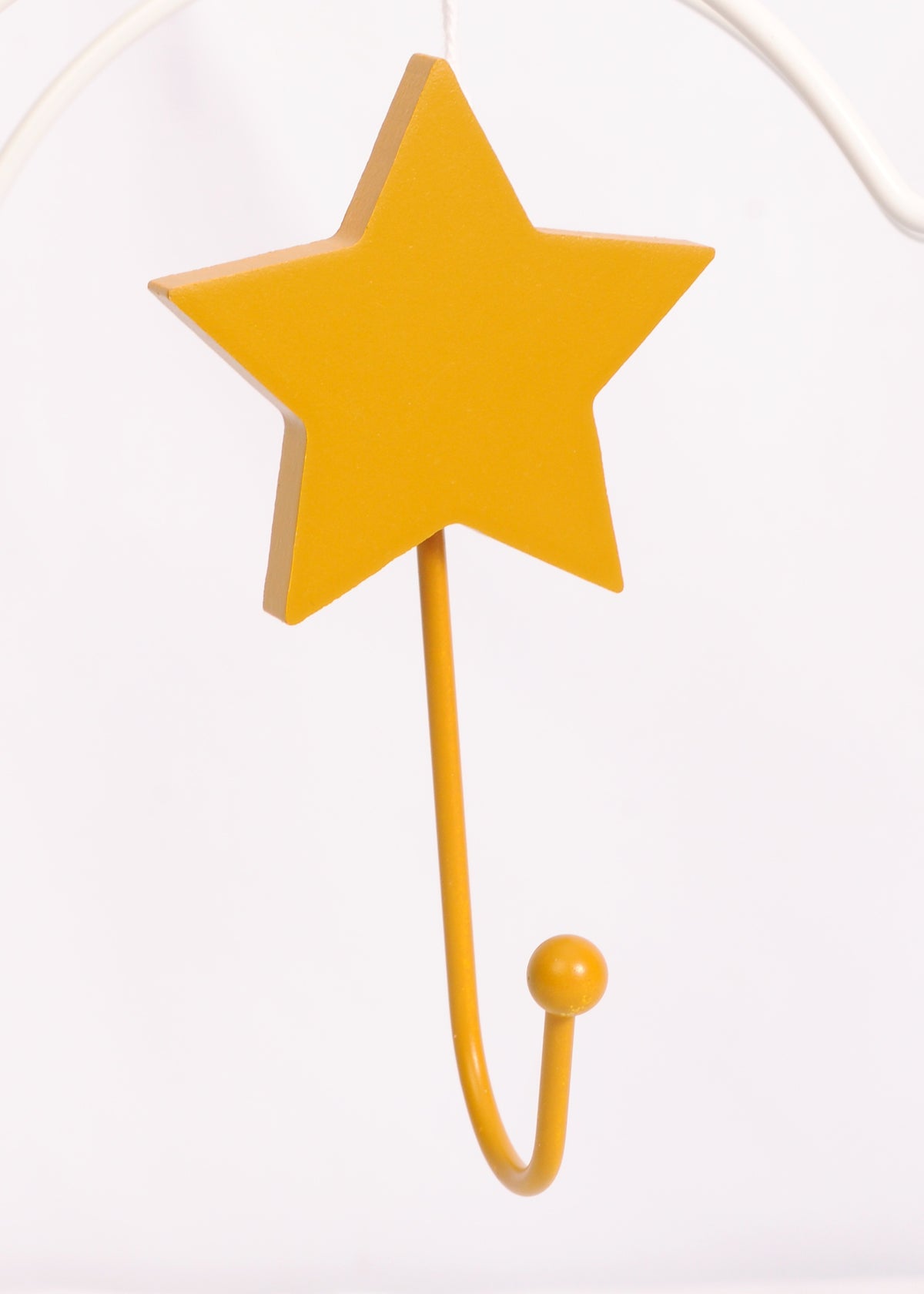Close-up of an ochre star-shaped wall hook with a curved hook and round end against a white background