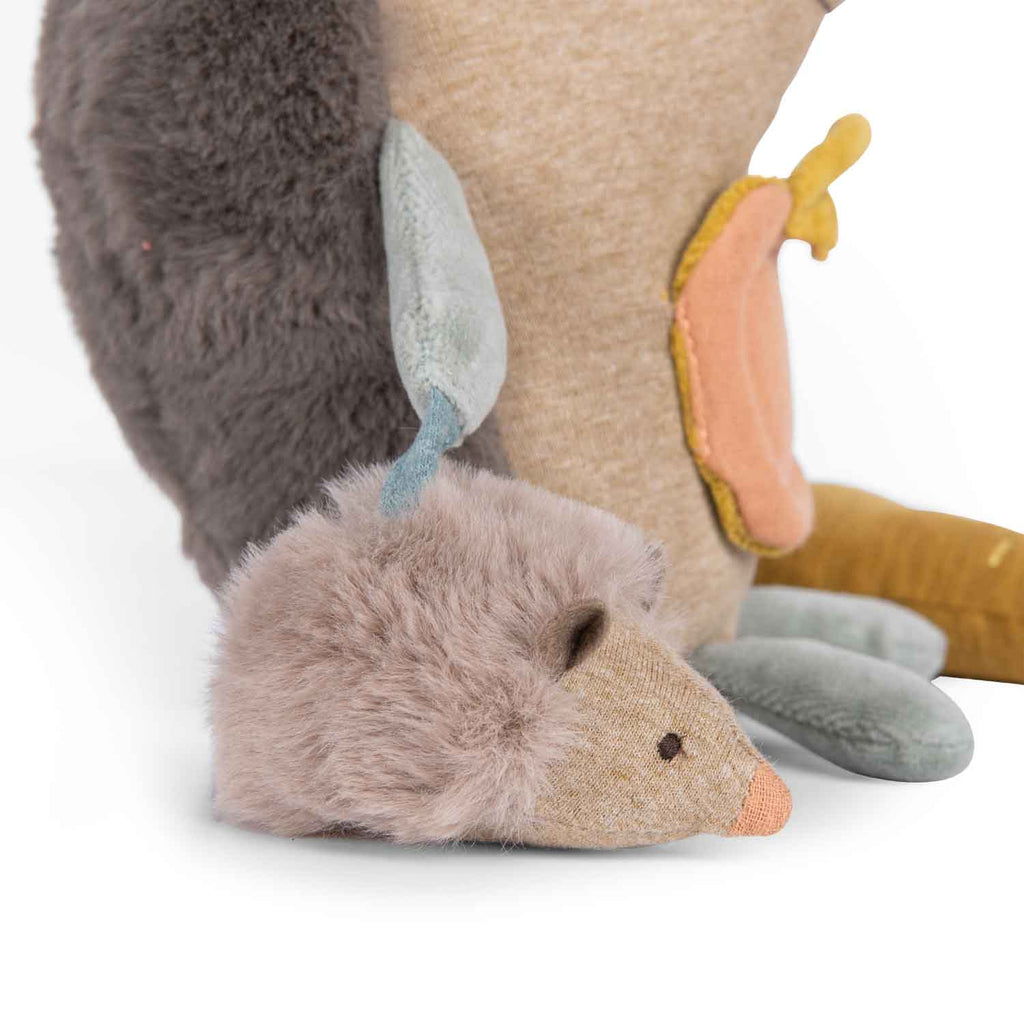 Close-up of a plush toy with a hedgehog-like head and animal body on a white background