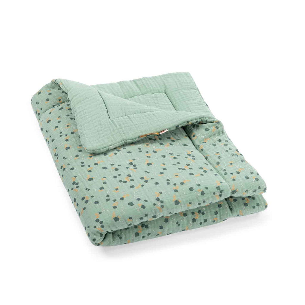 Sage green breathable baby quilt with a delicate botanical pattern, folded and displayed on a white background
