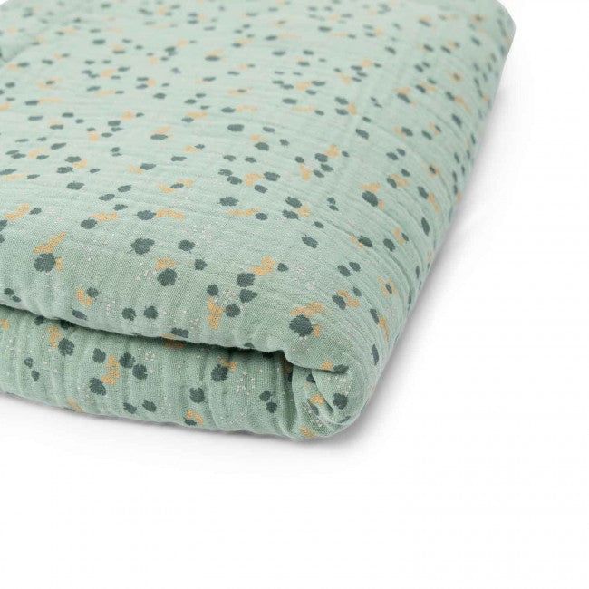 Close-up of a folded sage green baby quilt with a delicate botanical pattern on a white background